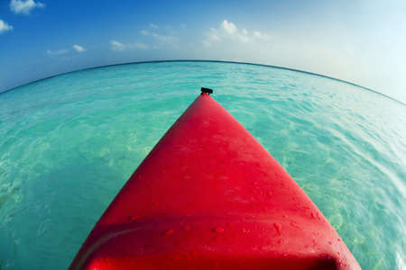 tropical beach: red canoa on the seashoreの写真素材