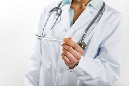 healthcare and medicine: young doctor taking temperatureの写真素材