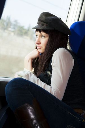 nice girl sitting on a train and looking out of the window