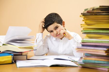little boy has troubles with homeworks and is scratching his head