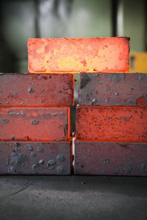piles of hot iron blocks in foundry. Narrow focus on central blockの写真素材