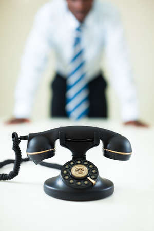 hesitant afro-american businessman staring at the phoneの写真素材