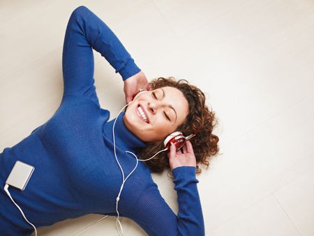 woman lying on floor and listening to music. Copy spaceの写真素材