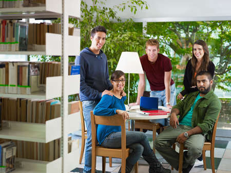 group of college students looking at camera in library. Horizontal shape, front view, full length