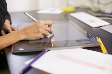 closeup of female dressmaker sketching and drawing dresses with graphic tablet. Horizontal shape,...