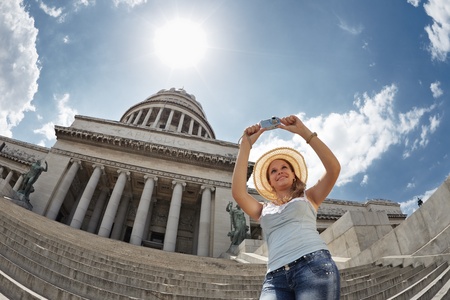 young adult blonde woman taking picture with digital camera in Havana, Cuba. Horizontal shape, waist up, low angleの写真素材