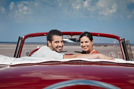 boyfriend and girlfriend sitting in vintage car and hugging in havana, cuba. Horizontal shape, side view, copy spaceの写真素材