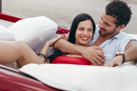 boyfriend and girlfriend lying inside vintage convertible car and hugging. Horizontal shape, side viewの写真素材