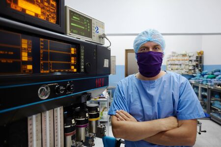 Portrait of caucasian doctor looking at camera in hospital surgery room with professional equipment and instrumentsの写真素材