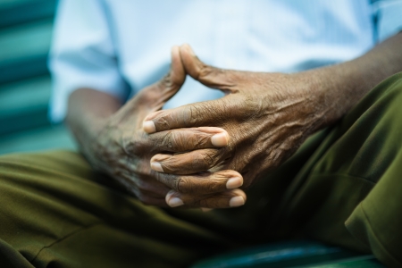 closeup of hands of elderly african american man sitting on benchの写真素材