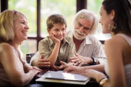 Happy family with husband, wife, child, grandfather and grandmother choosing food and drinks in bar