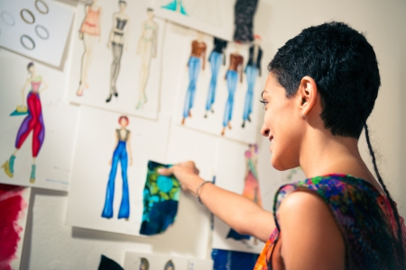 Young people and small business, hispanic woman at work as fashion designer and tailor, looking at...