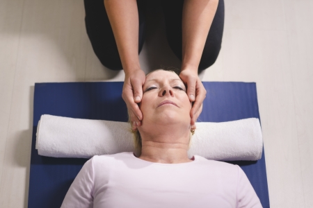 Alternative traditional medicine and massage, young spirit healer doing reiki treatment to old woman. High angle view, head and shouldersの写真素材