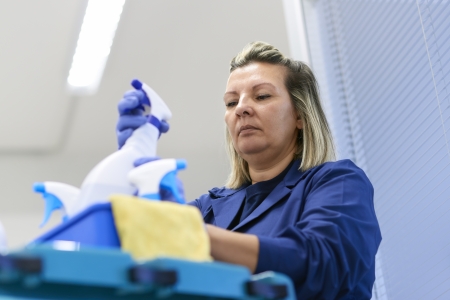 Women at work, portrait of professional female cleaner arranging bottles of detergents on trolley in officeの写真素材