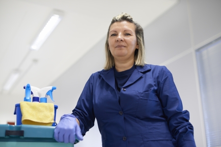Women at work, portrait of happy professional female cleaner smiling and looking at camera in office. Low angle viewの写真素材