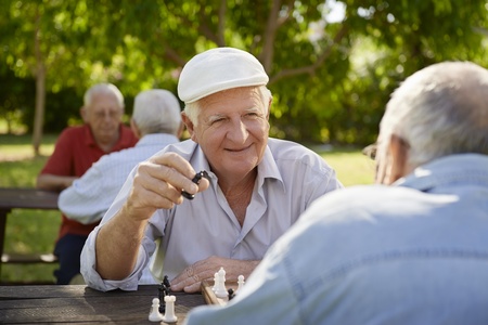 Active retired people, old friends and free time, two seniors having fun and playing chess game at...