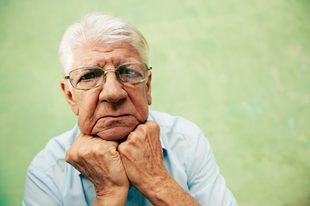 people and emotions, portrait of depressed senior hispanic man with glasses looking at camera, leaning with hands on chin. Copy spaceの写真素材