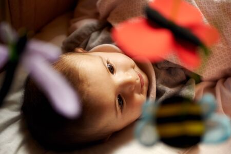 Children playing at home, happy cute little girl smiling and playing with toys and puppets in bedの写真素材