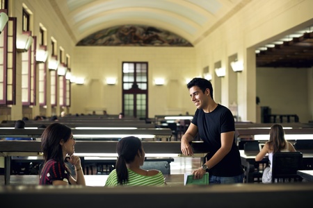 Group of happy students and friends studying at school, young men and women meeting and talking in college library, University of Havana, Cubaの写真素材