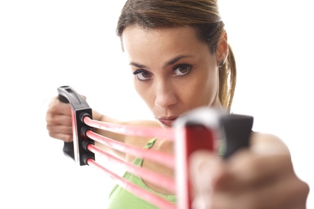 mid adult woman doing fitness exercise and training muscles with rubber band on white background 