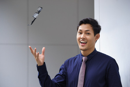 Portrait of confident businesman with eyesight myopia problem, throwing away his eyeglasses and...