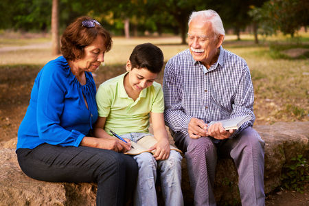 Grandparents educating grandson: Senior woman and old man spending time with their grandchild in...