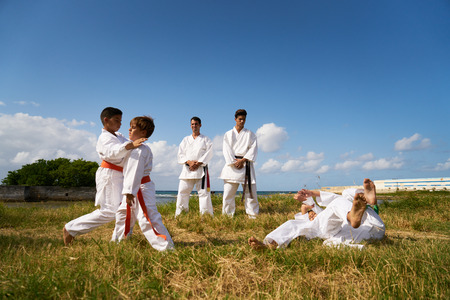 Combat and extreme sports, hispanic men and children exercising in karate and traditional martial...