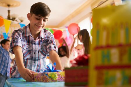 Group of happy children celebrating birthday at home, kids and friends having fun at party. Hispanic...