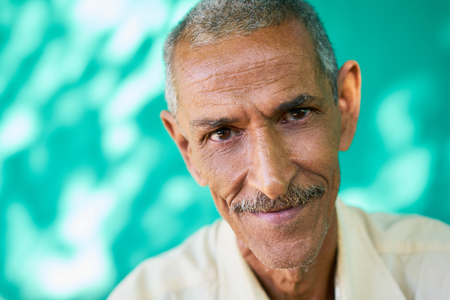 Real Cuban elderly people and feelings, portrait of happy old hispanic man with mustache from Havana, Cuba looking at camera and smilingの写真素材