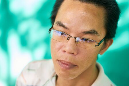 Real Cuban people with emotions and feelings, portrait of sad young asian-latino man with glasses...