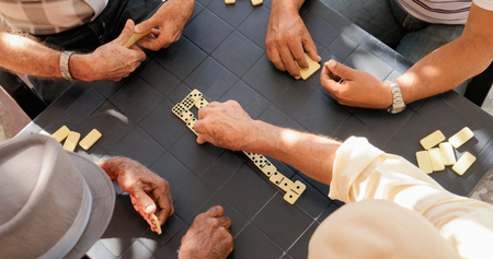 Retired people, seniors and free time. Old latino men having fun and playing game of domino in Cuba. High angle view.の写真素材