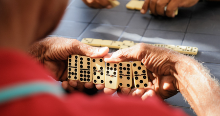 Retired people, seniors and free time. Old latino men having fun and playing game of domino in Cuba.の写真素材