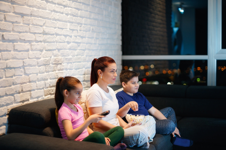 Single Mother And Children Watching TV At Nightの写真素材