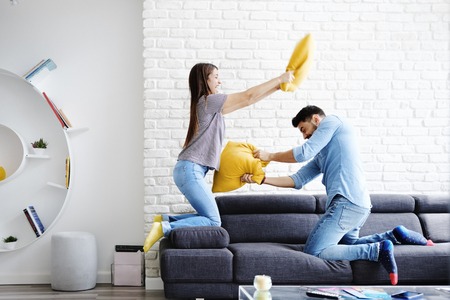 Portrait of Young Couple Playing Pillow Fightの写真素材