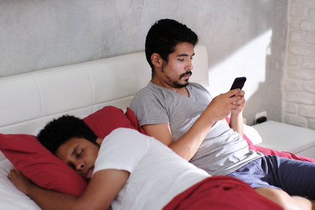 Man Cheating His Partner Texting On Smartphoneの写真素材