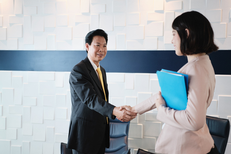 Handshake Between Happy Asian Manager And Hispanic Businesswoman In Officeの写真素材