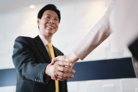 Handshake Between Happy Asian Manager And Hispanic Businesswoman In Officeの写真素材