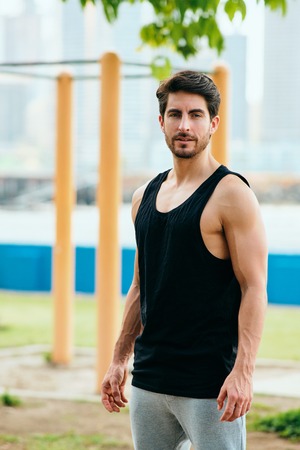 Portrait of Male Personal Trainer Working Out In City Park