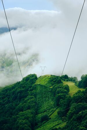 Power Line Pylon On Peak Of Mountain With Stormy Weatherの写真素材
