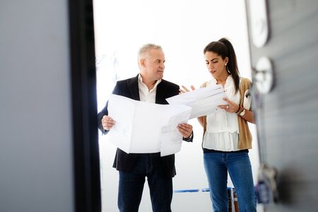 Teamwork With Boss And Assistant Looking At Plans In Building