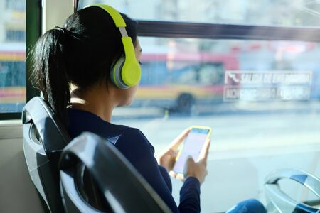 Woman With Headphones Listening To Music Commuting By Busの写真素材