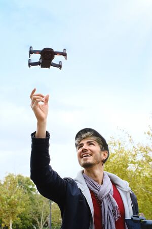 Young Man With Remote Control Landing Drone In His Hands