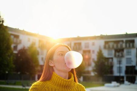 Young Woman Chewing Gum And Making Big Balloonの写真素材