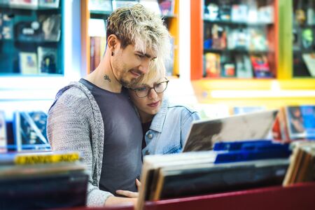 Young Couple Choosing Vintage Vinyl LP In Records Shopの写真素材