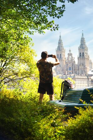Male Pilgrim Taking A Picture Of The Cathedral With Mobile Phone In Santiago De Compostela, Spanish Town At The End Of The Way Of St James.の写真素材