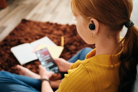 Little Redhead Girl Studying And Listening Music At Home