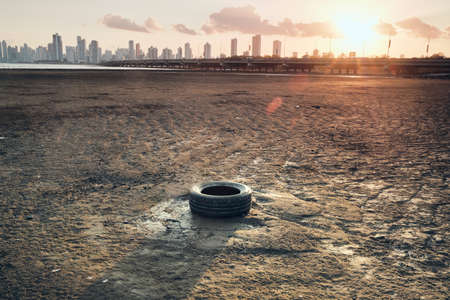 Discarded Tyre And Plastic Pollution On Seashore