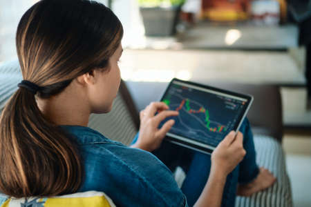 Woman Trading Online Using Tablet Computer On Sofaの写真素材