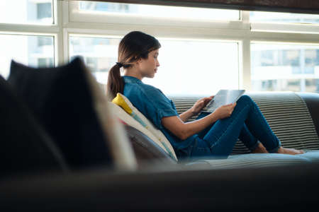 Woman Choosing Movie For Streaming On Tablet Computerの写真素材