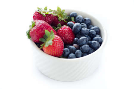 blueberries and strawberries in white bowl の写真素材